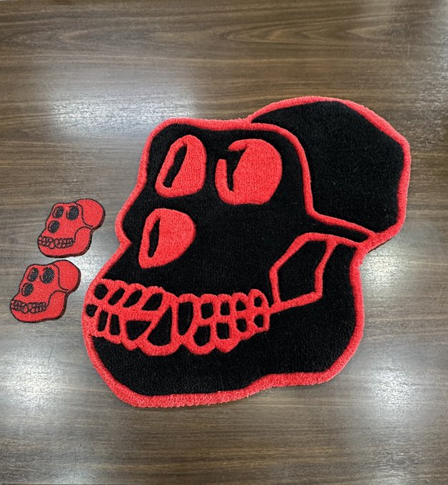Red and black embroidered chenille patches shaped like skulls, featuring a large skull design alongside two smaller matching skull patches, displayed on a wooden surface.