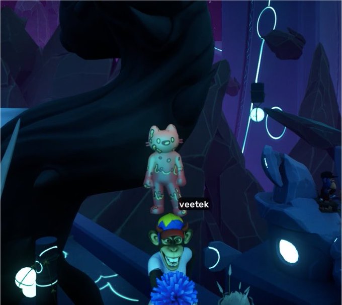 A screenshot from a 3D virtual world or game showing avatars in a dark, crystalline environment with glowing neon lights; a translucent pinkish cat-like avatar is labeled 'veetek', with other avatars visible below.