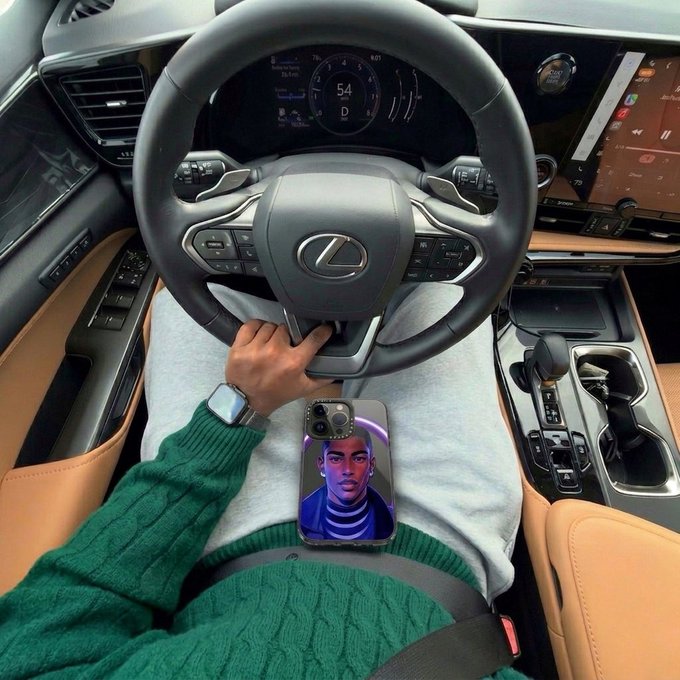 A first-person view from the driver's seat of a Lexus, showing a person in a green sweater holding the steering wheel with a smartphone resting on their lap displaying an illustration of a face.