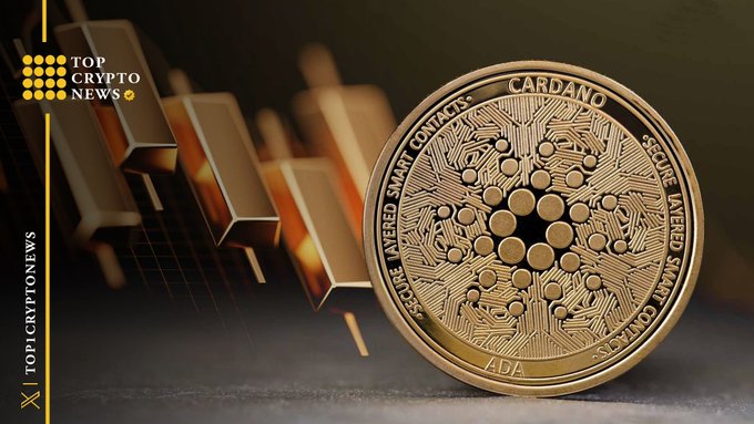 A physical gold-colored Cardano (ADA) cryptocurrency coin resting against a gold bar, branded with "TOP CRYPTO NEWS".