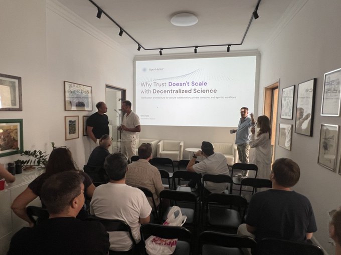 A group of people attending a presentation in an art gallery setting, with a projector screen displaying 'Why Trust Doesn't Scale with Decentralized Science' by Hyperfutures.