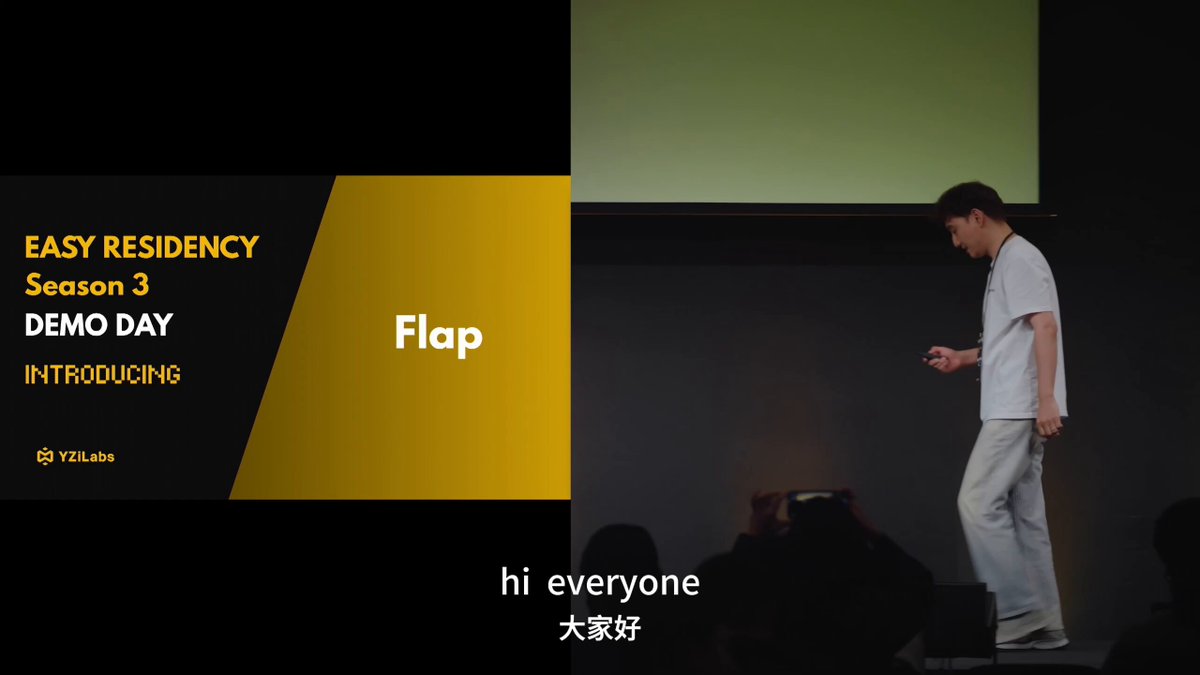 The image features a man standing on a stage, holding up his hands as if giving instructions or making a speech. The background of the image is black with yellow text that reads "Easy Residence Season 3 Demo Day Introducing". This suggests that the man might be presenting something related to Easy Residence, possibly an event or product launch.