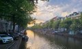 The image shows a picturesque view of a canal with several boats floating along its surface. The sky above the canal has a beautiful sunset, casting an orange glow over the scene. In the foreground, there are parked cars lining the side of the canal, adding a touch of urban life to this serene setting. The post also mentions that "Litecoin OGs press forward united in our mission to make LTC known worldwide." This could be interpreted as a reference to the cryptocurrency market and its growth over time.