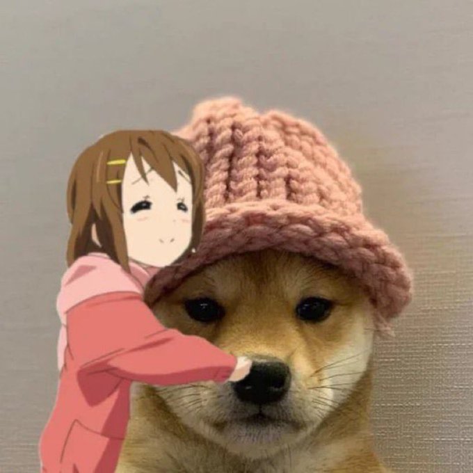 An adorable Shiba Inu dog wearing a pink knitted beanie hat, with an anime-style chibi character (appears to be Hirasawa Yui from K-On!) digitally added, smiling and hugging the dog from the side.