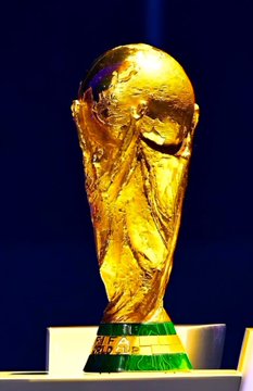 The FIFA World Cup trophy is displayed on a stand against a dark background, representing the prestigious prize that the listed countries—France, Spain, England, and Argentina—are competing for according to the Polymarket odds.