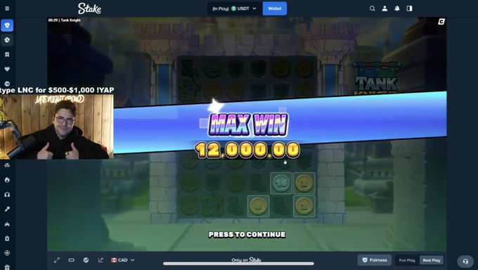 A streaming screenshot of a man in the corner watching a 'MAX WIN 12,000.00' notification pop up while playing the game 'Tank Knight' on Stake.