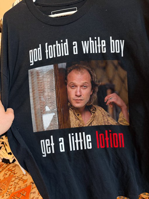 A black t-shirt featuring Ted Levine as Buffalo Bill from 'The Silence of the Lambs' with the text 'god forbid a white boy get a little lotion'.