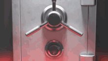 The image shows a close-up view of an inside shot of a silver safe, with its lock button illuminated red. The safe appears to be made of metal and has a keyhole located at the bottom center of the frame. The background is dark, which makes the safe stand out prominently in the image.