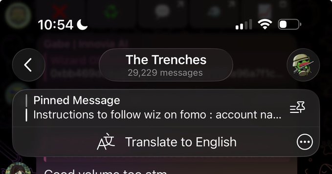 A smartphone screenshot shows a messaging group called "The Trenches" with 29,229 messages, featuring a pinned message titled "Instructions to follow wiz on fomo" and a "Translate to English" option, highlighting the active nature of this memecoin trading chat referenced in the post.
