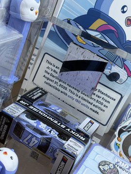 A NASCAR race car-themed PENGU collectible with an acrylic display, noting it's piece #31 of 150 made and referencing @dyli_io.