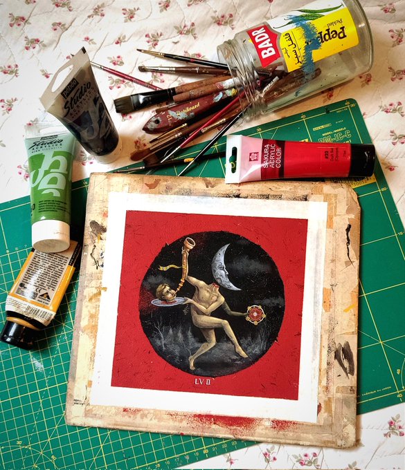 The image shows a painting with a woman's head, surrounded by various art supplies such as paintbrushes, tubes of paint, and a canvas. The painting appears to be unfinished or in progress, possibly being created for an art project or exhibition. The post seems to be about the importance of dreams and how they can be shared through music, specifically the song "Beheaded Ballad of the Moon".