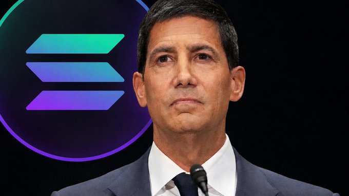 A man in a suit stands at a podium with the Solana logo displayed behind him, contextualizing the news of the Federal Reserve's $27.6 billion economic injection as bullish for the SOLANA cryptocurrency.