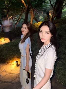 Two women pose together in a beautifully lit Japanese-style garden setting, with lush greenery, trees, and warm pathway lighting creating an elegant atmosphere that perfectly matches the event venue description. The serene, aesthetic backdrop complements the post's praise of the venue's "Japanese garden vibes" and the photography capturing the ambiance.