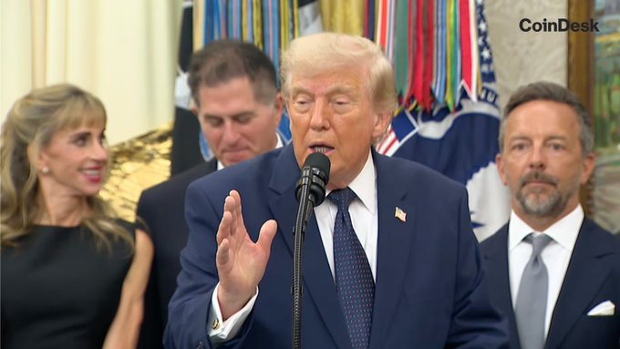 President Trump speaks at a podium with the CoinDesk logo visible, relating to a proposal to index capital gains to inflation, which could impact $BTC and $ETH holders.