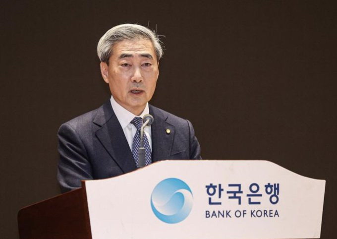 Bank of Korea Governor Rhee Chang-yong speaks at a podium bearing the "BANK OF KOREA / 한국은행" logo, addressing the institution's first rate hike since 2023—a 25 bps increase to 2.75% that signals tighter monetary conditions for South Korea's highly active retail crypto market.