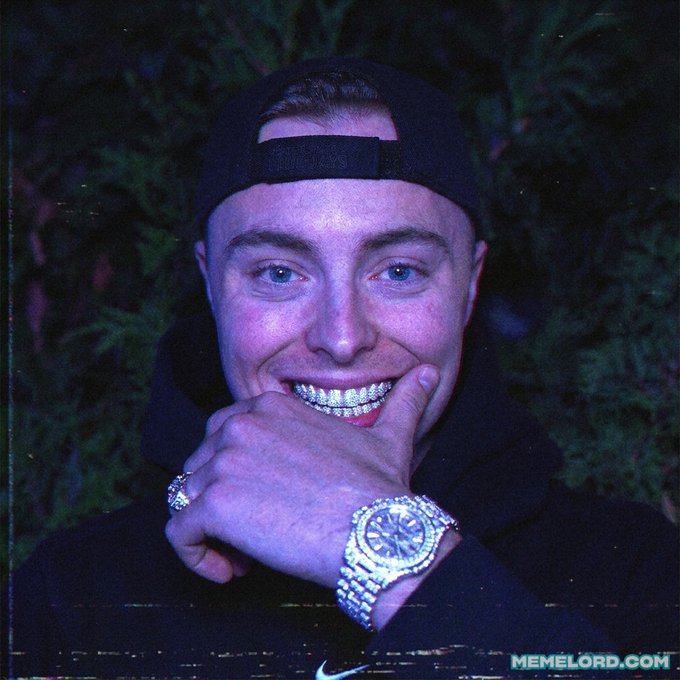 Stylized portrait photograph of a young man wearing a backwards black cap, diamond-encrusted grillz, a large diamond-encrusted watch, and rings, with the watermark 'memelord.com' at the bottom.