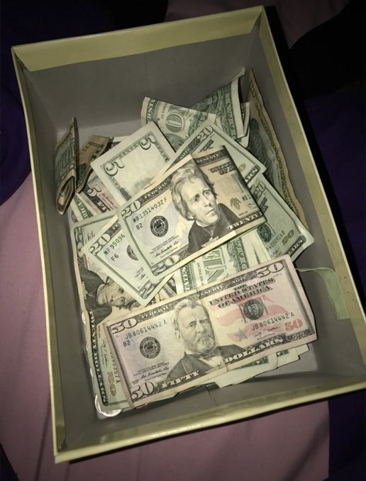 A box overflowing with US dollar bills, including $50 and $20 denominations, humorously relates to the post's sentiment of having too much money to enjoy simple pleasures like "touching grass."