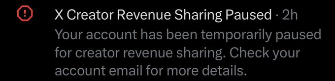 The image shows an X (formerly Twitter) notification displaying a red warning icon with the message "X Creator Revenue Sharing Paused - 2h" and the text "Your account has been temporarily paused for creator revenue sharing. Check your account email for more details."

The notification confirms the poster's suspicion that their creator revenue sharing has been suspended, directly relating to their post about expecting a red alert and asking if other creators are experiencing similar issues.