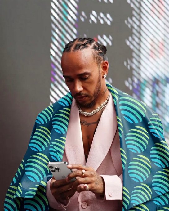 The image features a man wearing a pink suit jacket, holding a cell phone with his left hand while looking at it with his right hand. The background of the photo shows a window that has blinds drawn over it, suggesting an indoor setting or possibly a room where he is currently located.

The post includes text that reads "Finishing second yesterday reminded me how you always made me finish first... I get it now... you are my pole position". This message seems to be related to the man in the pink suit jacket and his cell phone, as if the image was taken during a moment of reflection or contemplation.

The caption also mentions that he should've just used Jupiter, which could be interpreted as a reference to the popular social media platform where people often share photos and messages with their friends.