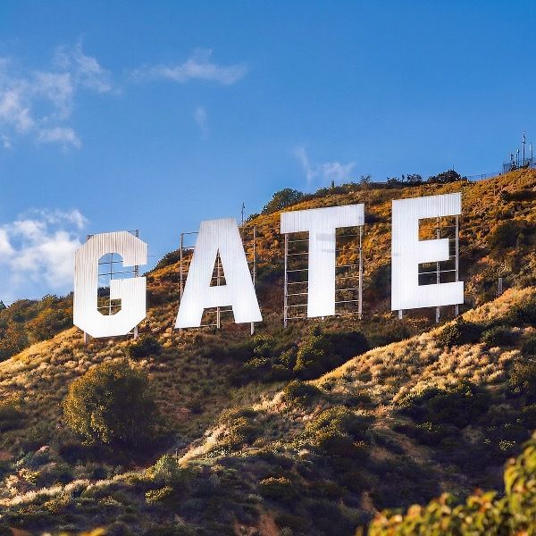 The image shows the iconic "GAITE" letters spelling out a sign on a hillside, matching the caption "You know the sign. You know the Gate." — likely referring to the well-known Calabasas landmark where the last "C" is hidden by the hill, creating the "Gate" illusion.