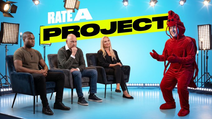 A promotional image for 'RATE A PROJECT' showing three seated judges and a person dressed in a red lobster costume against a blue background.