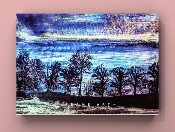 A framed canvas print displayed against a pink wall, featuring an abstract landscape with silhouetted trees and a blue-toned sky, with the text 'FRAME ART_' visible at the bottom.