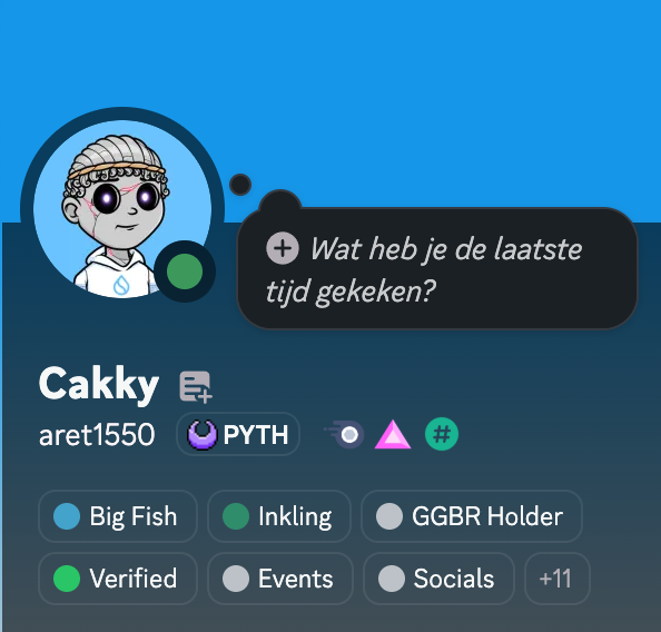 The image shows a Discord profile card for user "Cakky" (aret1550) with a status message in Dutch asking "Wat heb je de laatste tijd gekeken?" (What have you been watching lately?), featuring PytheniansNFT and other badges. This corresponds to the post celebrating earning the "Big Fish" role on the Goldfish GGBR community, with the visible Big Fish badge confirming the achievement mentioned in the accompanying text.