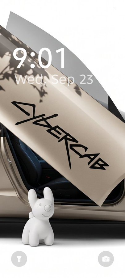 A phone lockscreen from Wednesday, September 23 at 9:01, featuring a white cartoon rabbit figurine next to a tan car with its "GAMER RAB" door open.