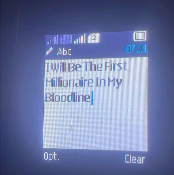 A close-up of a small device screen with a phone keypad displaying the typed message: 'I will Be The First Millionaire In My Bloodline'.