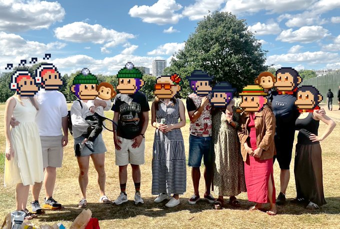 A group of people pose together at an outdoor gathering in a park, with their faces playfully covered by pixel-art "monke" avatars in various colors and accessories, reflecting the crypto community theme. The sunny setting and casual attire complement the caption's mention of a fun afternoon hosted with fellow monkes, co-hosted by @rhtdoesweb3 for MonkeDAO and SolanaMBS.