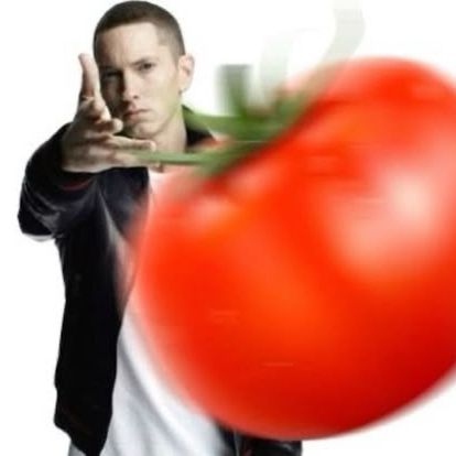 A man in a black jacket points dramatically at a giant red tomato in the foreground, with no visible text or numbers in the image. The oversized tomato likely serves as a playful visual metaphor for "throwing" or "dropping" a meme coin, relating to the crypto trading post about meme token holdings.
