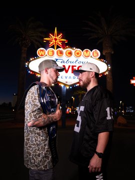 Two men stand facing each other in front of the iconic "Welcome to Fabulous Las Vegas Nevada" sign at night. The post promotes their welterweight title bout for Power Slap 21, airing live and free on YouTube at 10p ET/7p PT.