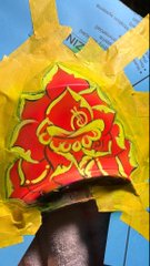 A close-up photograph of a graffiti piece featuring stylized red and yellow lettering on a red background, surrounded by yellow paint, likely on a wall or door.