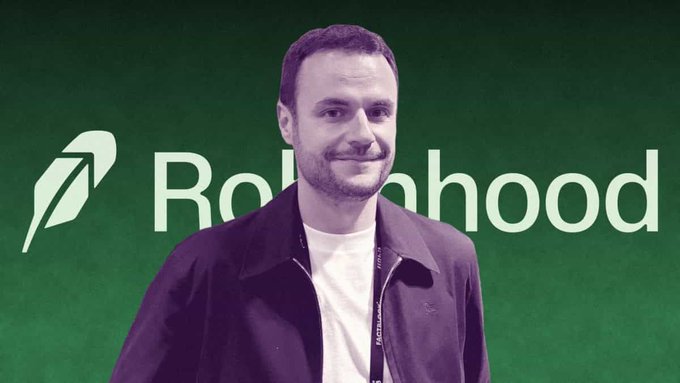 A man with short brown hair and a beard stands smiling in front of a green backdrop featuring the 'Robinhood' logo and name.