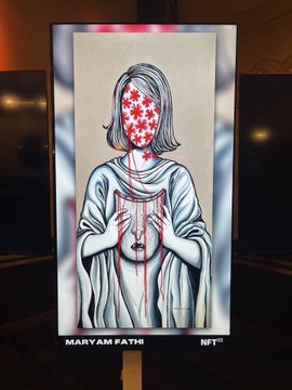 A digital display showing artwork by Maryam Fatih labeled as an NFT, featuring a hooded figure with a face covered in red stars and hands with blood-like streaks across the chest.
