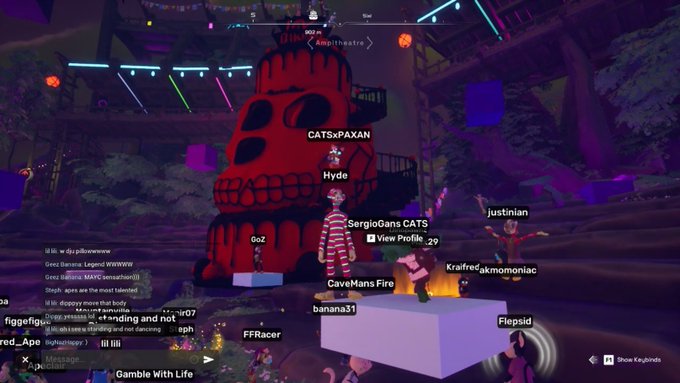 Screenshot of a virtual world game with avatars like SergioGans CATS, justinian, and CaveMansFire gathered around a large pumpkin-shaped structure and campfire, with a 'Gamble With Life' event label.