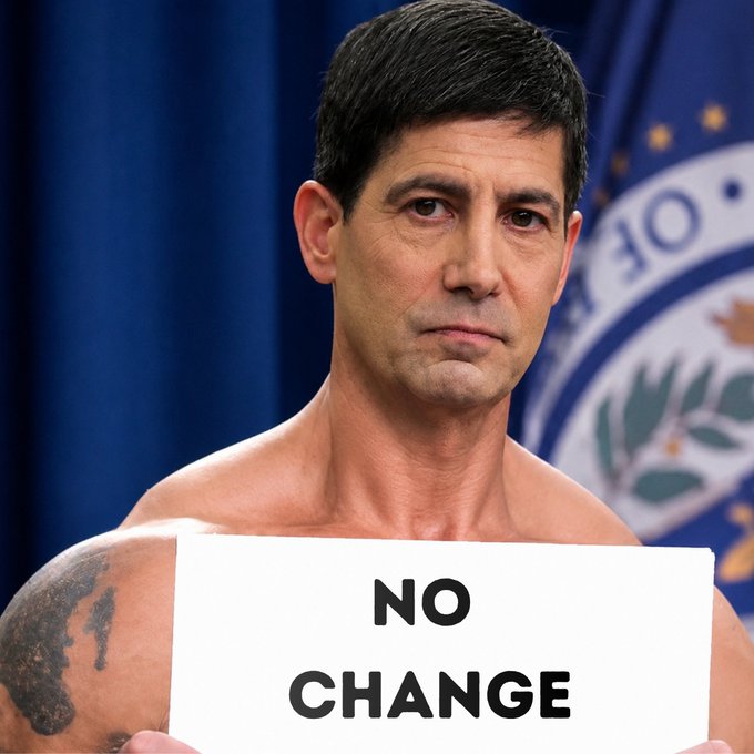 A shirtless man with a tattoo on his left shoulder holds a sign reading "NO CHANGE" in front of a blue official seal backdrop. The image humorously illustrates the FOMC's announcement of no interest rate change, visually emphasizing the "no change" outcome.