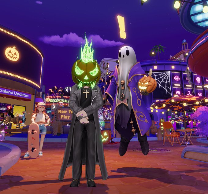 Two Halloween-themed video game avatars—a figure with a flaming pumpkin head in a black coat and a ghost in a purple robe holding a jack-o'-lantern—stand in a festive virtual town square.
