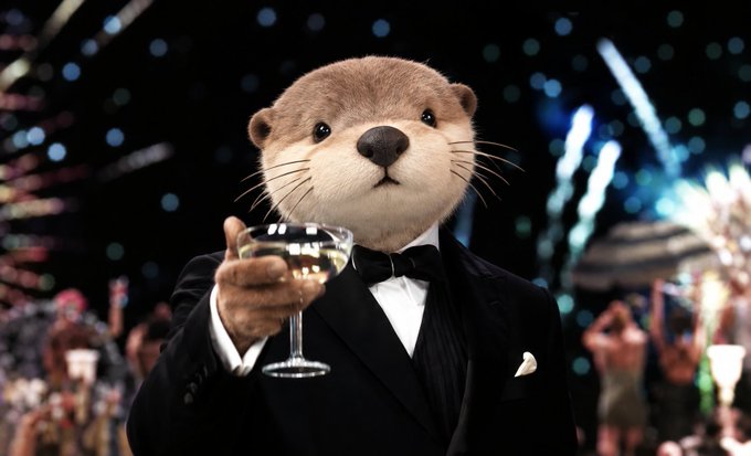 An animated otter wearing a black tuxedo and bow tie raises a glass of champagne, with fireworks and a festive crowd in the background.