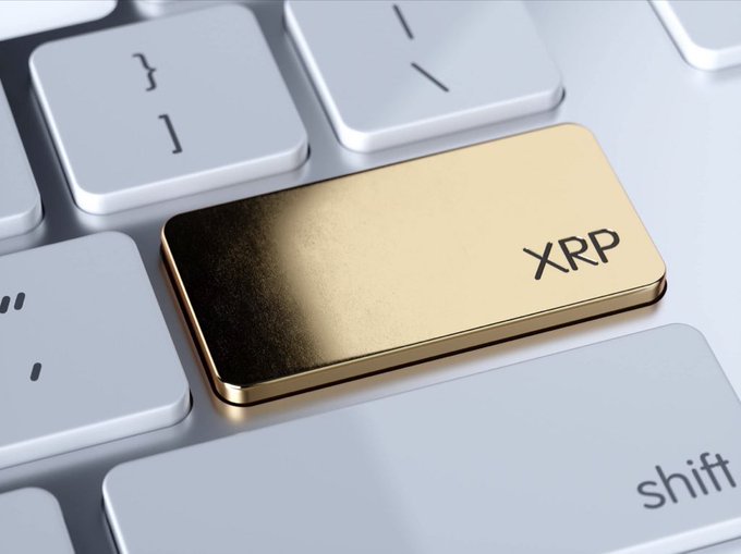 A close-up of a computer keyboard featuring a prominent gold-colored key labeled 'XRP' positioned where the backspace or enter key would typically be.