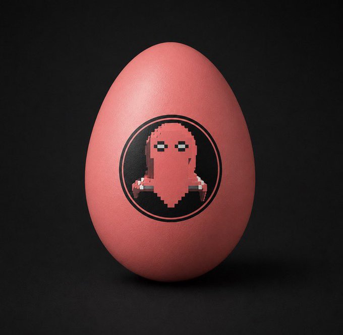 A pink egg-shaped object on a dark background, featuring a circular logo with a pixel-art ghost or creature design.