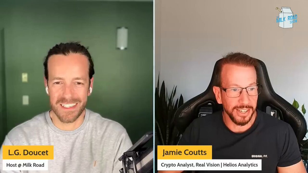 The image shows two men sitting behind microphones, likely participating in a podcast or radio show. They are both smiling at the camera, appearing engaged in conversation with each other. The background of the image features a green wall, which complements the overall color scheme of the scene.