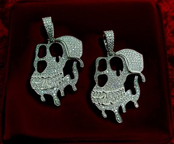 Two diamond-encrusted pendants shaped like melting "P" letters rest on a red velvet display, representing the custom prize that Playful Primates SBT holders on MetaMask Rewards can win before the mint closes. The dripping letter design reflects the brand's melting-style logo, serving as a tangible incentive for community members to mint their Soulbound Token and join the Discord.