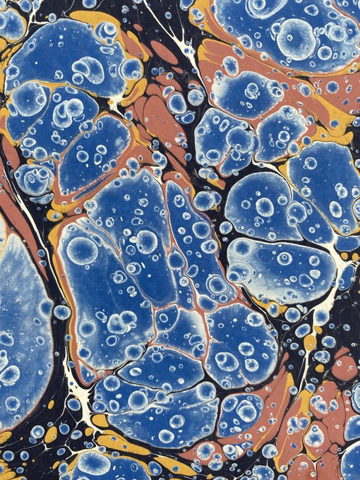 An abstract painting featuring blue cellular or bubble-like shapes against a background of orange, yellow, and black swirls.