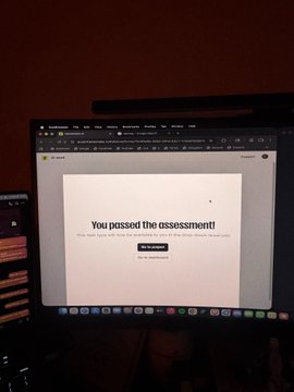 A photo of a laptop screen displaying 'You passed the assessment!' with a 'Go to dashboard' button.