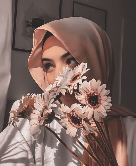 A woman wearing a beige hijab holds a bouquet of sunflowers in front of her face on a bright, sunny morning, complementing the cheerful "Good morning, happy weekend" message.
