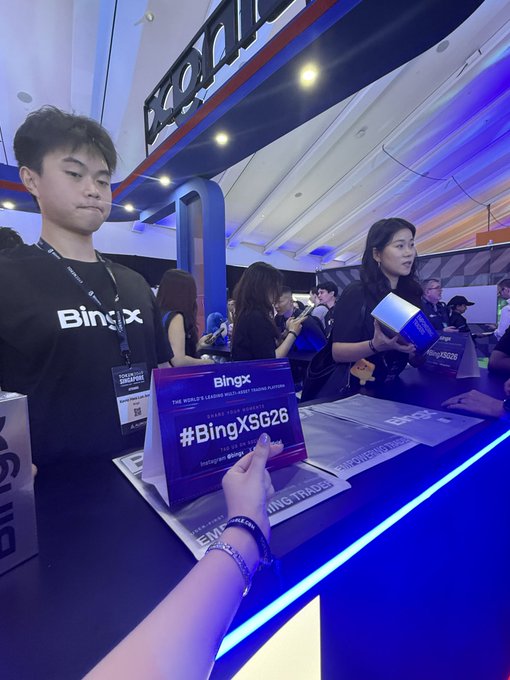 A BingX cryptocurrency trading booth at an event with staff members and a sign displaying '#BingXSG26' for 'THE WORLD'S LEADING INNOVATIVE TRADING PLATFORM'.