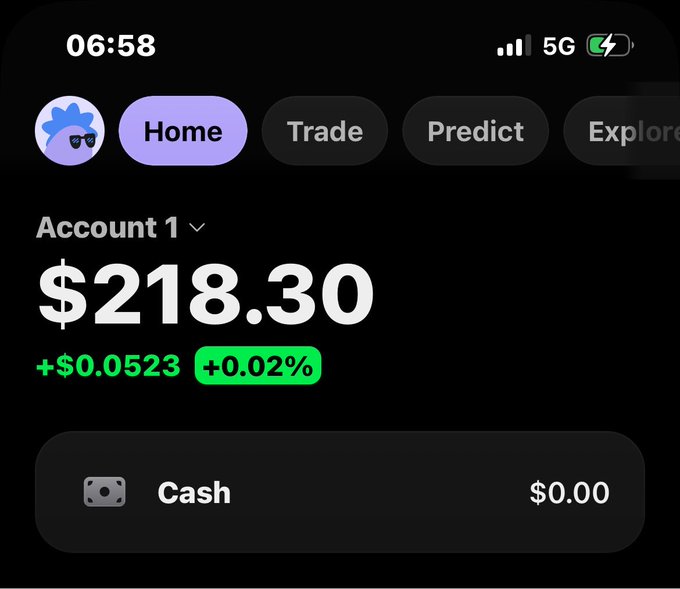 A mobile screenshot shows an account balance of $218.30, up +$0.0523 (+0.02%), with $0.00 cash on the Home tab of what appears to be a trading app. The image relates to the post as a "win" reference to a small but positive gain on the account.