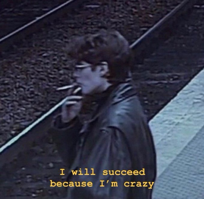 The image features a man standing next to train tracks, smoking a cigarette while wearing glasses. Below his head, there's text that reads "I will succeed because I'm crazy". The phrase "You have to be crazy to het crazy amounts of money" is also present in the image. This combination of elements creates an interesting juxtaposition between the man's seemingly eccentric behavior and the message about success.