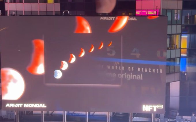 A large billboard advertising ARIJIT MONDAL with phase images and text 'THE WORLD OF REACHER', 'me original', and 'NFT now'.